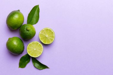 Yeşil yapraklı kireç meyveleri ve beyaz arka planda yarım dilim kesilmiş. Üst Manzara. Kopyalama alanı olan düz.