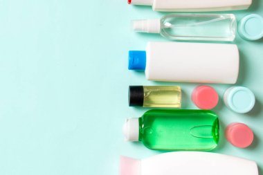 Farklı kavanozlardaki kozmetik ürünlerinin ve renkli arka plandaki şişelerin üst görüntüsü. Kopyalama alanı olan konteynırların kapatılması.