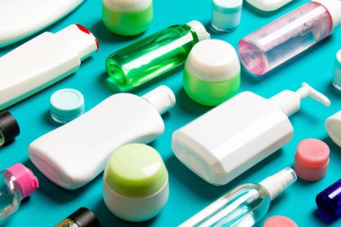 Renkli arka plandaki kozmetik ürünleri için farklı boyutlarda şişeler ve kavanozlar. Fotokopi alanı ile yüz ve vücut bakımı kavramı.