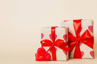 gift box with red bow and red heart on colored background. Perspective view. Flat lay.