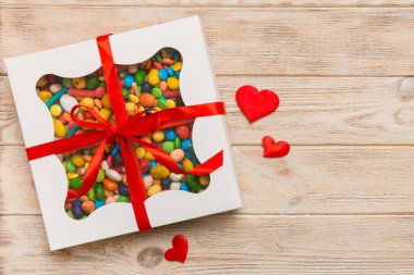 Valentine day composition: sweet candy, with gift boxes with bow and red felt hearts, photo template, background. Top View with copy space.