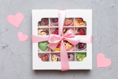 Valentine day composition: sweet candy, with gift boxes with bow and red felt hearts, photo template, background. Top View with copy space.