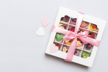 Valentine day composition: sweet candy, with gift boxes with bow and red felt hearts, photo template, background. Top View with copy space.
