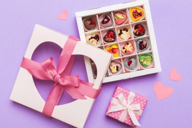 Valentine day composition: sweet candy, with gift boxes with bow and red felt hearts, photo template, background. Top View with copy space.