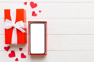 Opened gift box with ribbon and phone on color background, top view. Blank open box packaging mockup , Template for your design - branding mockup.