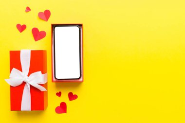 Opened gift box with ribbon and phone on color background, top view. Blank open box packaging mockup , Template for your design - branding mockup.