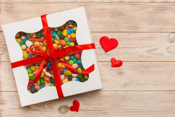 Valentine day composition: sweet candy, with gift boxes with bow and red felt hearts, photo template, background. Top View with copy space.