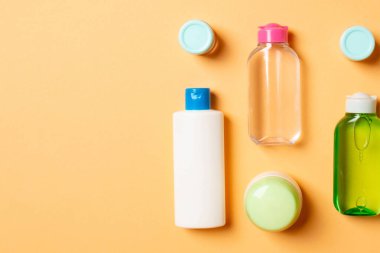 Kozmetik SPA marka modeli, fotokopi alanı olan üst görünüm. Renkli arka planda duran krema tüpleri ve kavanozları..