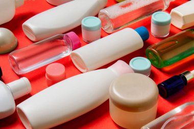 Plastik gövde bakımı şişesi düz kompozisyonu ve renkli arka plan boşluğuna kozmetik ürünler dizayn edilmişti. Beyaz Kozmetik kapları kümesi, kopya alanı ile üst görünüm.