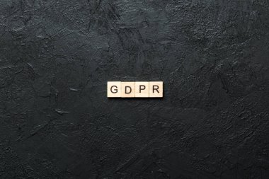 Tahta blokta GDPR kelimesi yazıyor. Genel Veri Koruma Yönetmeliği metni desing, konsept için çimento tablo üzerinde.