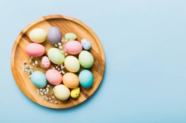 Mutlu Paskalya kompozisyonu. Paskalya yumurtaları renkli masada, çingeneyle birlikte. Doğal boyalı renkli yumurtalar arkaplan arkaplan görünümü kopya alanı ile.