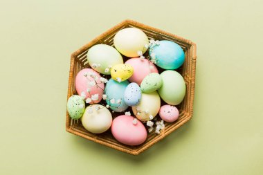 Mutlu Paskalya kompozisyonu. Paskalya yumurtaları renkli masada, çingeneyle birlikte. Doğal boyalı renkli yumurtalar arkaplan arkaplan görünümü kopya alanı ile.