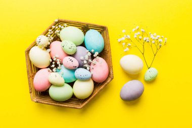 Mutlu Paskalya kompozisyonu. Paskalya yumurtaları renkli masada, çingeneyle birlikte. Doğal boyalı renkli yumurtalar arkaplan arkaplan görünümü kopya alanı ile.
