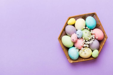 Mutlu Paskalya kompozisyonu. Paskalya yumurtaları renkli masada, çingeneyle birlikte. Doğal boyalı renkli yumurtalar arkaplan arkaplan görünümü kopya alanı ile.