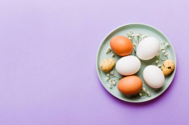 Mutlu Paskalya kompozisyonu. Paskalya yumurtaları renkli masada, çingeneyle birlikte. Doğal boyalı renkli yumurtalar arkaplan arkaplan görünümü kopya alanı ile.