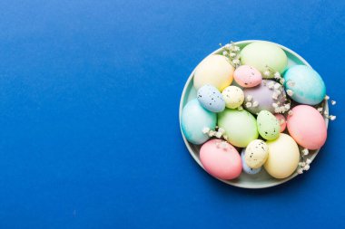 Mutlu Paskalya kompozisyonu. Paskalya yumurtaları renkli masada, çingeneyle birlikte. Doğal boyalı renkli yumurtalar arkaplan arkaplan görünümü kopya alanı ile.