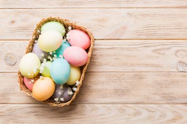 Mutlu Paskalya kompozisyonu. Paskalya yumurtaları renkli masada, çingeneyle birlikte. Doğal boyalı renkli yumurtalar arkaplan arkaplan görünümü kopya alanı ile.
