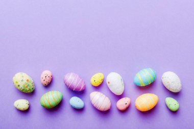 Renkli arka planda dekoratif paskalya yumurtaları. Paskalya yumurtaları kopyalama alanı olan üst görünüm koleksiyonu.