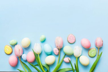 Mutlu Paskalya kompozisyonu. Renkli masada sarı laleli Paskalya yumurtaları. Doğal boyalı renkli yumurtalar arkaplan arkaplan görünümü kopya alanı ile.