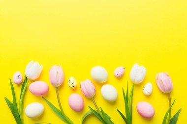 Mutlu Paskalya kompozisyonu. Renkli masada sarı laleli Paskalya yumurtaları. Doğal boyalı renkli yumurtalar arkaplan arkaplan görünümü kopya alanı ile.