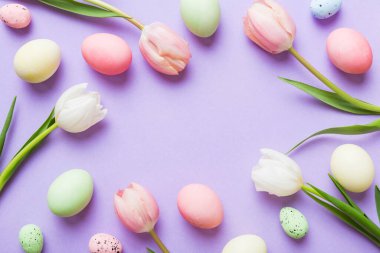 Mutlu Paskalya kompozisyonu. Renkli masada sarı laleli Paskalya yumurtaları. Doğal boyalı renkli yumurtalar arkaplan arkaplan görünümü kopya alanı ile.