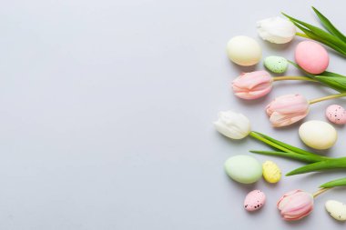 Mutlu Paskalya kompozisyonu. Renkli masada sarı laleli Paskalya yumurtaları. Doğal boyalı renkli yumurtalar arkaplan arkaplan görünümü kopya alanı ile.