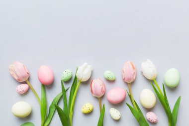 Mutlu Paskalya kompozisyonu. Renkli masada sarı laleli Paskalya yumurtaları. Doğal boyalı renkli yumurtalar arkaplan arkaplan görünümü kopya alanı ile.