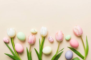 Mutlu Paskalya kompozisyonu. Renkli masada sarı laleli Paskalya yumurtaları. Doğal boyalı renkli yumurtalar arkaplan arkaplan görünümü kopya alanı ile.