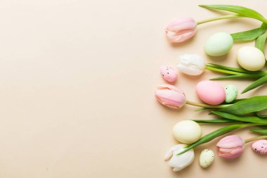 Mutlu Paskalya kompozisyonu. Renkli masada sarı laleli Paskalya yumurtaları. Doğal boyalı renkli yumurtalar arkaplan arkaplan görünümü kopya alanı ile.