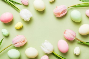 Mutlu Paskalya kompozisyonu. Renkli masada sarı laleli Paskalya yumurtaları. Doğal boyalı renkli yumurtalar arkaplan arkaplan görünümü kopya alanı ile.