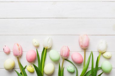 Mutlu Paskalya kompozisyonu. Renkli masada sarı laleli Paskalya yumurtaları. Doğal boyalı renkli yumurtalar arkaplan arkaplan görünümü kopya alanı ile.