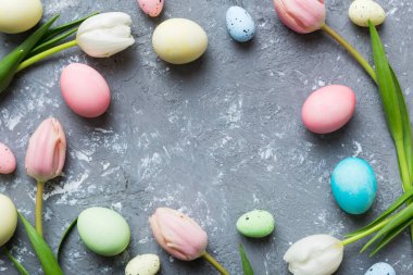 Mutlu Paskalya kompozisyonu. Renkli masada sarı laleli Paskalya yumurtaları. Doğal boyalı renkli yumurtalar arkaplan arkaplan görünümü kopya alanı ile.