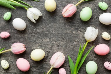 Mutlu Paskalya kompozisyonu. Renkli masada sarı laleli Paskalya yumurtaları. Doğal boyalı renkli yumurtalar arkaplan arkaplan görünümü kopya alanı ile.
