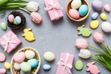 Yumurtalı Paskalya çerçevesi, renkli bir arka planda hediye kutusu ve lale. Minimum konsept. Üst Manzara Mutlu Paskalyalar kompozisyonu. Metin için yerin bir kopyasına sahip kart.