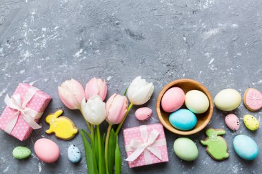 Yumurtalı Paskalya çerçevesi, renkli bir arka planda hediye kutusu ve lale. Minimum konsept. Üst Manzara Mutlu Paskalyalar kompozisyonu. Metin için yerin bir kopyasına sahip kart.