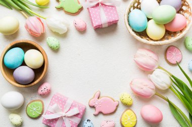 Yumurtalı Paskalya çerçevesi, renkli bir arka planda hediye kutusu ve lale. Minimum konsept. Üst Manzara Mutlu Paskalyalar kompozisyonu. Metin için yerin bir kopyasına sahip kart.