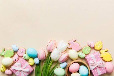 Yumurtalı Paskalya çerçevesi, renkli bir arka planda hediye kutusu ve lale. Minimum konsept. Üst Manzara Mutlu Paskalyalar kompozisyonu. Metin için yerin bir kopyasına sahip kart.
