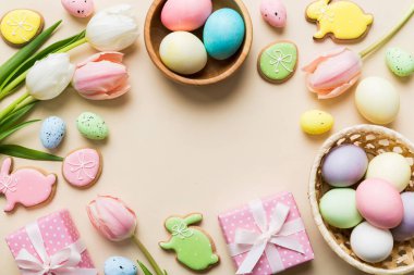 Yumurtalı Paskalya çerçevesi, renkli bir arka planda hediye kutusu ve lale. Minimum konsept. Üst Manzara Mutlu Paskalyalar kompozisyonu. Metin için yerin bir kopyasına sahip kart.