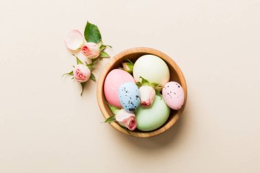 Mutlu Paskalyalar. Renkli masada sarı güllerle birlikte Paskalya yumurtaları. Doğal boyalı renkli yumurtalar arkaplan arkaplan görünümü kopya alanı ile.
