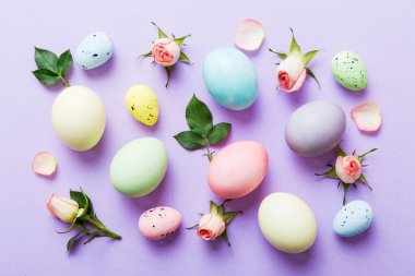 Mutlu Paskalyalar. Renkli masada sarı güllü Paskalya yumurtaları. Doğal boyalı renkli yumurtalar arkaplan arkaplan görünümü kopya alanı ile.