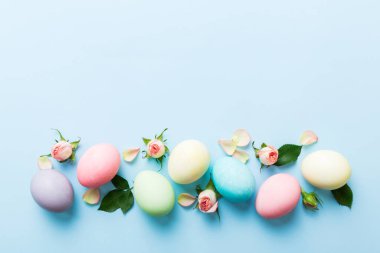Mutlu Paskalyalar. Renkli masada sarı güllü Paskalya yumurtaları. Doğal boyalı renkli yumurtalar arkaplan arkaplan görünümü kopya alanı ile.