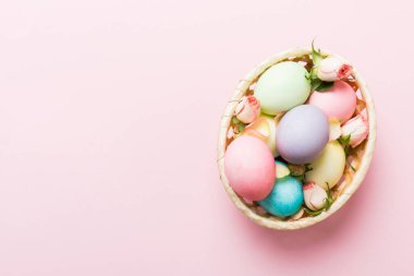 Mutlu Paskalyalar. Renkli masada sarı güllerle birlikte Paskalya yumurtaları. Doğal boyalı renkli yumurtalar arkaplan arkaplan görünümü kopya alanı ile.