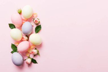 Mutlu Paskalyalar. Renkli masada sarı güllü Paskalya yumurtaları. Doğal boyalı renkli yumurtalar arkaplan arkaplan görünümü kopya alanı ile.