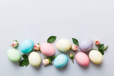 Mutlu Paskalyalar. Renkli masada sarı güllü Paskalya yumurtaları. Doğal boyalı renkli yumurtalar arkaplan arkaplan görünümü kopya alanı ile.