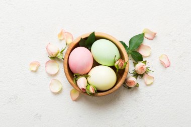 Mutlu Paskalyalar. Renkli masada sarı güllerle birlikte Paskalya yumurtaları. Doğal boyalı renkli yumurtalar arkaplan arkaplan görünümü kopya alanı ile.