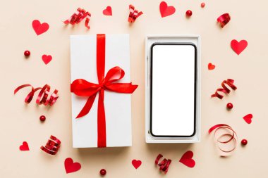 Opened gift box with ribbon and phone on color background, top view. Blank open box packaging mockup , Template for your design - branding mockup.