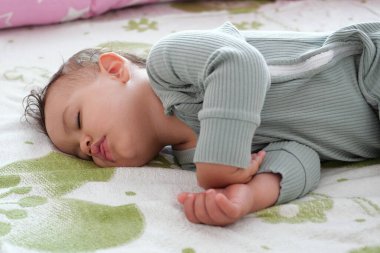 Yatakta uyuyan güzel bir bebeğin yakın plan portresi. Anne kavramından yeni aile ve bebek koruması.