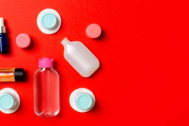 Renkli arka planda seyahat boyutunda kozmetik şişeler. Krema kavanozları düzdü. Vücut bakım stili kavramının en üst görünümü.