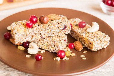 Arka planda çeşitli granola barlar var. Mısır gevreği gofretleri. Yulaf, fındık ve böğürtlenli kahvaltı barları, yakın çekim. Süper yiyecek konsepti.