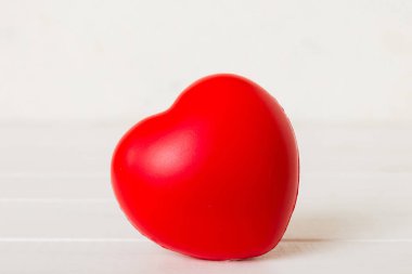 gift box with red bow and red heart on colored background. Perspective view. Flat lay.